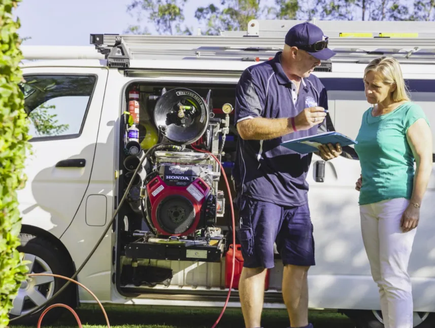 Big Blue Plumbing plumber talking a customer through the job at the van