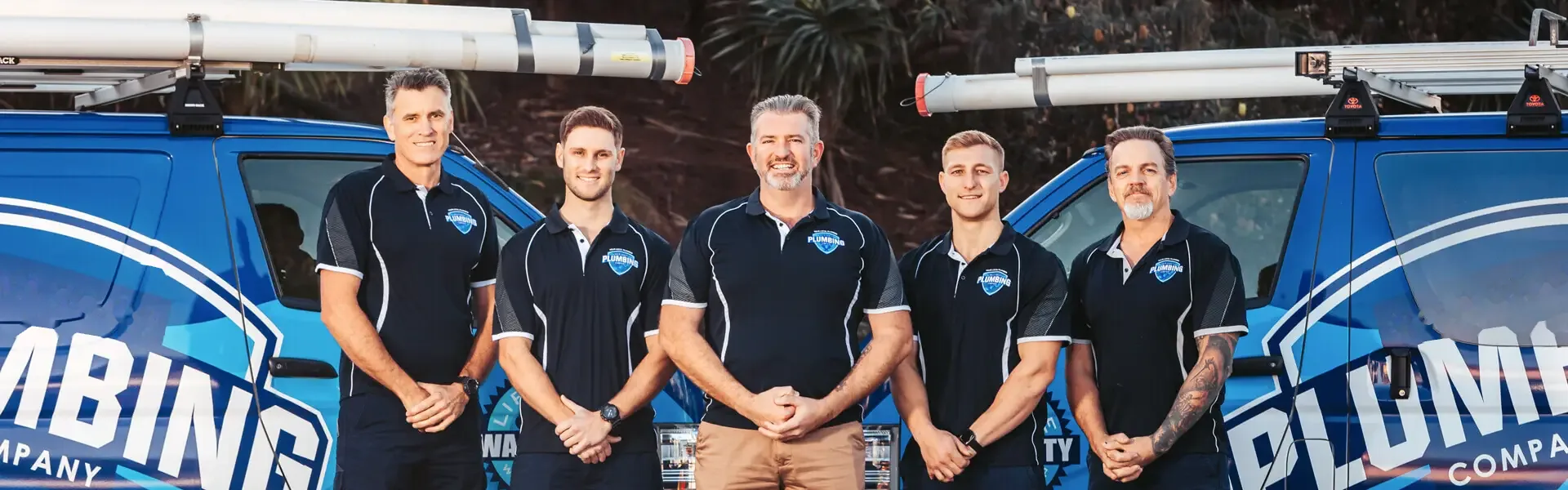 The Big Blue Plumbing team in front of two vans
