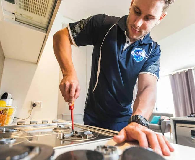 Gas fitter working on a cooktop