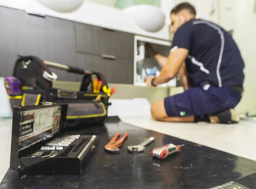 Plumber working under a kitchen sink