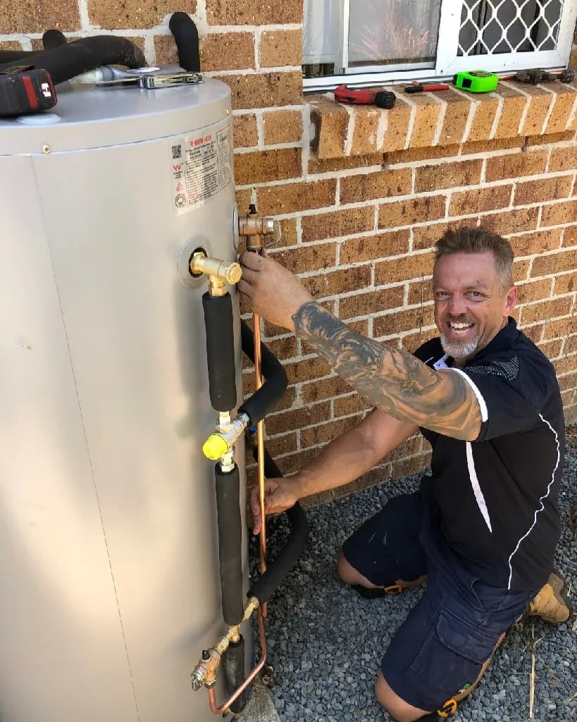 Plumber installing a hot water system