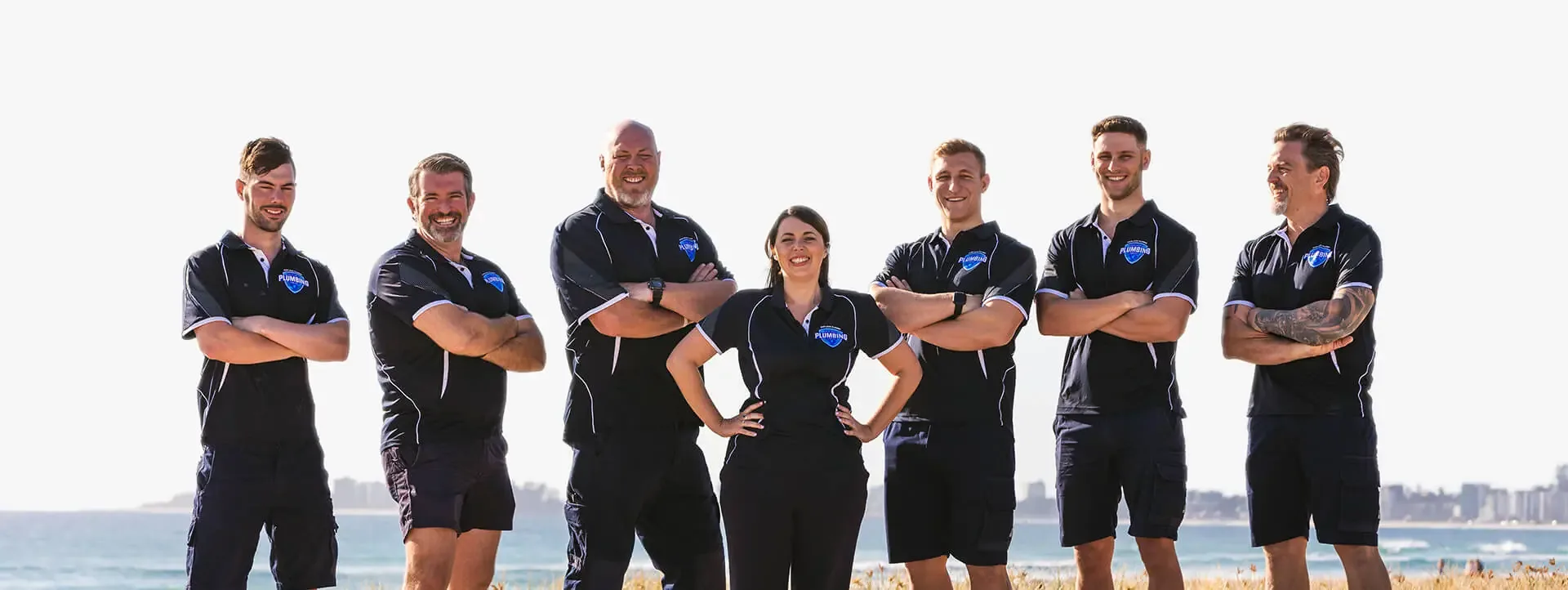 The Big Blue Plumbing team standing on the beach